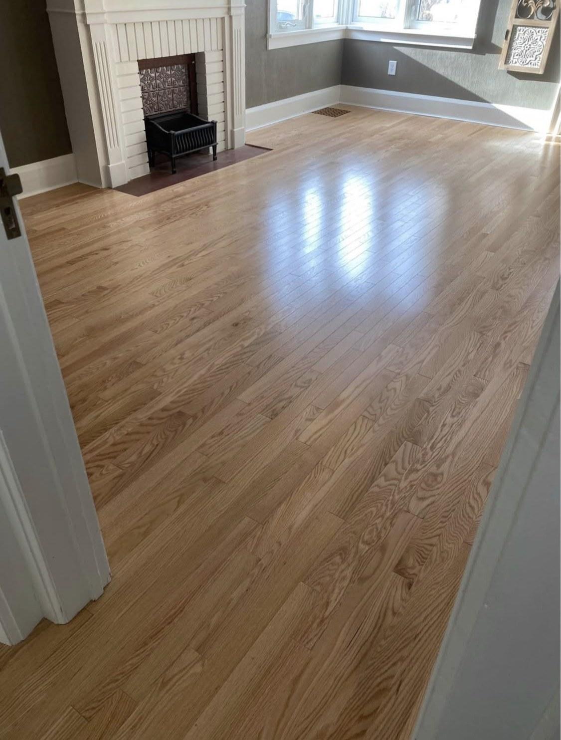 Bright living room with a light natural wood floor and white fireplace
