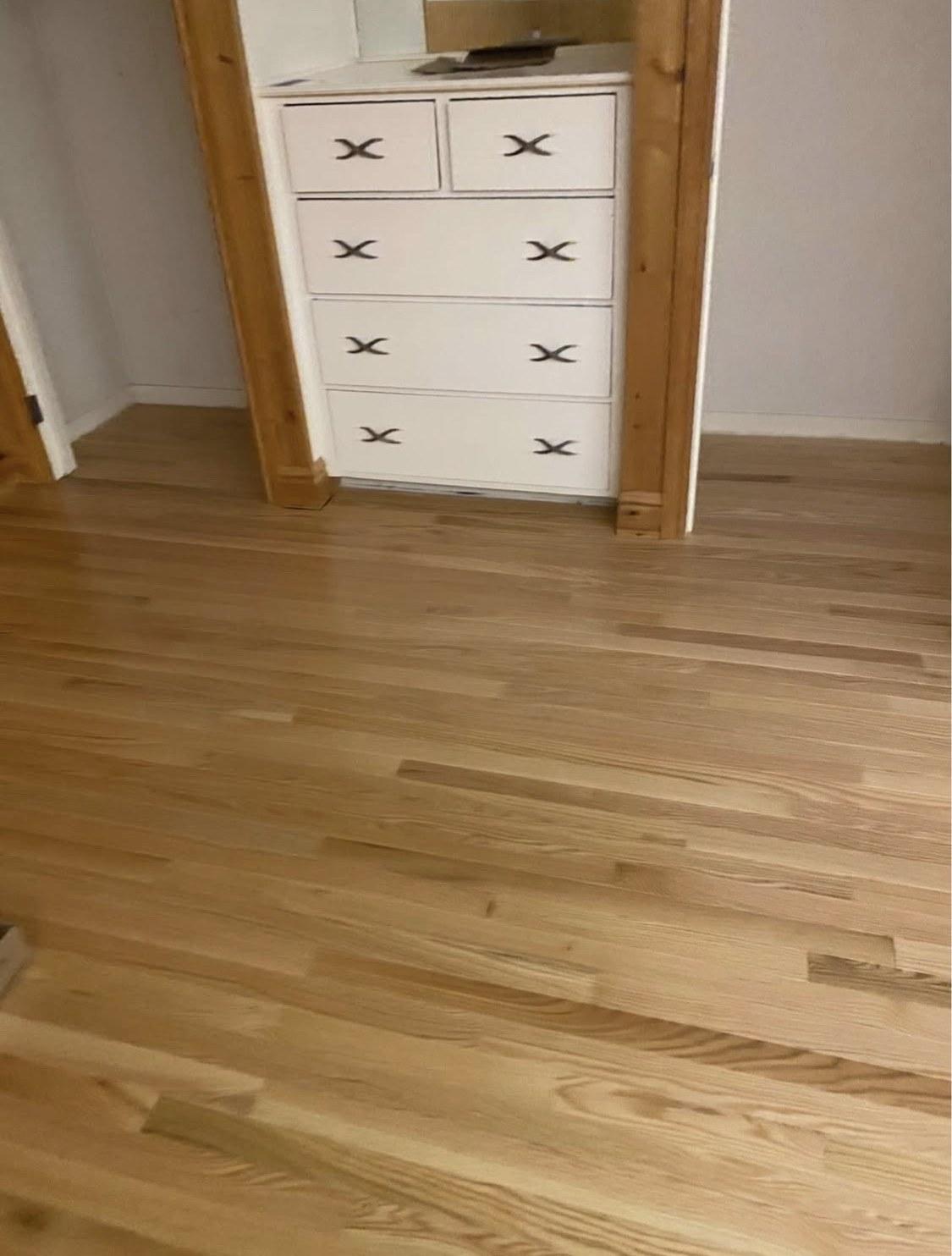 Bedroom or dressing area with warm wood flooring around built-in cabinetry