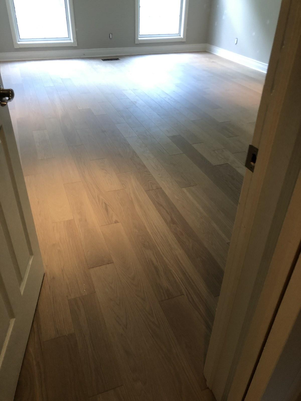 Bright empty room with a wall-to-wall light wood floor
