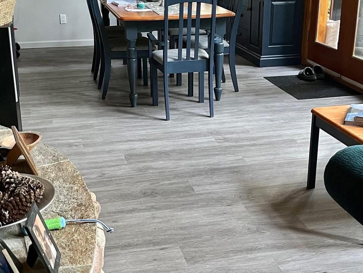 Open dining and living area with grey plank flooring